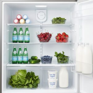 Image 3 : A vibrant, healthy refrigerator shelf stocked with fresh greens, a bowl of cherries, and bottles of water.