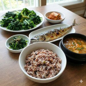 Image 2: A vibrant, colorful table set with steamed fish, a bowl of mixed grain rice, and an abundance of green leafy vegetables.
