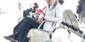 An elderly traveler relaxing in an airport lounge, representing safe and comfortable air travel.