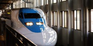 A sleek Shinkansen bullet train at a modern Japanese station.