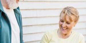 An elderly couple enjoying cool water in a sunny garden setting.