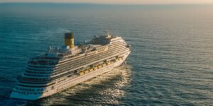 A luxurious cruise ship sailing into the sunset on a calm ocean.
