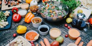 A table filled with Mediterranean-inspired whole foods like nuts, vegetables, and olive oil.
