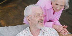 An older couple talking in a bright, comfortable living room, representing the importance of social connection and healthy aging.