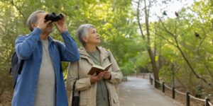 Older couple birdwatching on an accessible park path