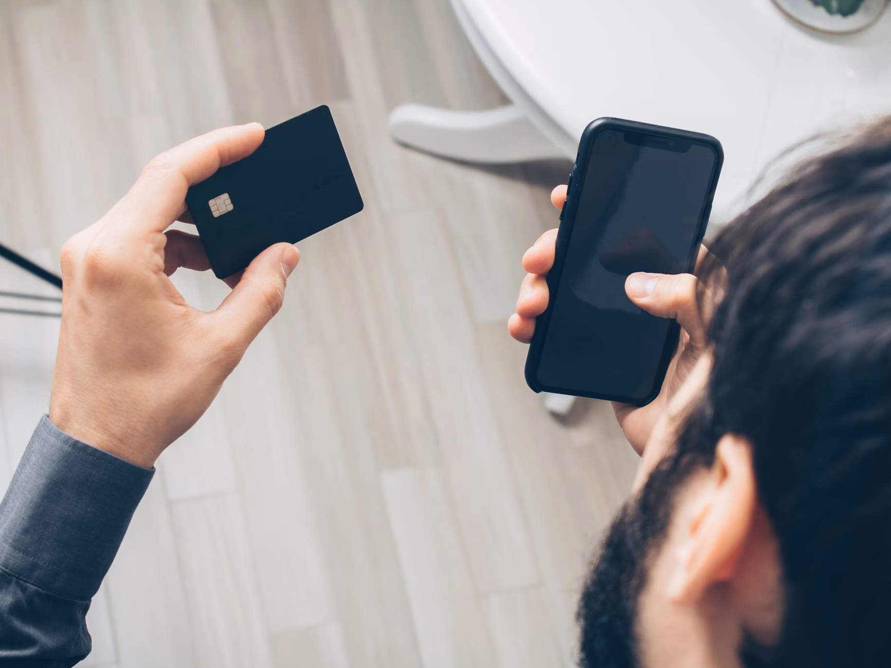 Hands using a smartphone for secure banking and biometric authentication.