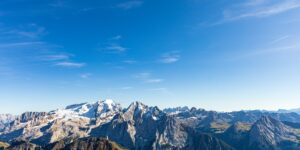A breathtaking mountain range under a clear blue sky, representing high-altitude travel destinations.