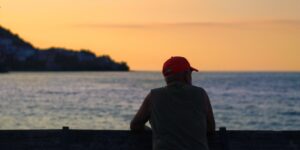 A senior traveler enjoying a serene sunset view from a luxury cruise ship deck.