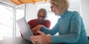 Seniors using modern technology to connect with family in a bright, welcoming community space.
