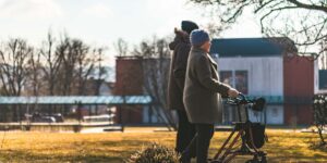 An older couple strolling through a scenic garden, representing joyful and healthy travel.