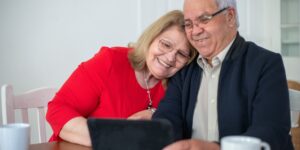 A senior couple using a tablet in a bright living room.