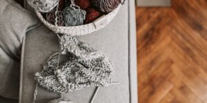 A cozy scene with yarn and knitting supplies in a bright living room.