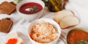 A selection of fermented foods including sauerkraut and kefir on a wooden table.
