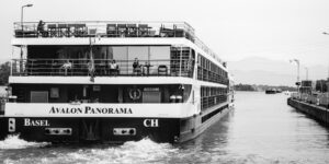 A majestic river cruise ship sailing down the Rhine past a historic castle.