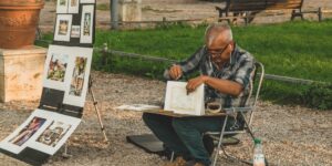 A senior person enjoying urban sketching in a peaceful public park setting.