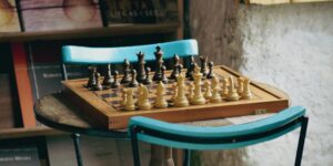 A wooden chessboard on a sunlit table, symbolizing the intellectual joy of chess for seniors.