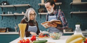 A healthy senior couple preparing a nutritious meal in a sunlit kitchen.