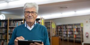 A senior person using a tablet to access public services in a comfortable home setting.