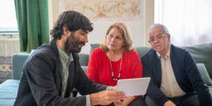An older adult confidently managing finances on a tablet in a well-lit, modern home office.