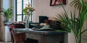 A cozy community room set up for a memoir writing group with notebooks and pens.