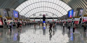 A bright, modern airport terminal with senior travelers walking toward their gate.