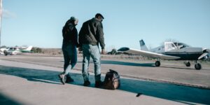An active senior couple preparing for a flight at an airport gate with a digital boarding pass.