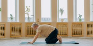 An elderly person practicing gentle neck mobility exercises in a comfortable home environment.