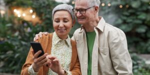 A senior couple using a smartphone to navigate a historic city center.