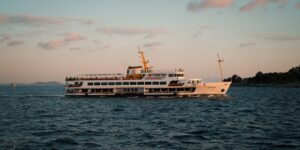 A cruise ship sailing on the open ocean at sunset.