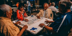 A group of seniors enjoying a board game together in a bright, comfortable living room.