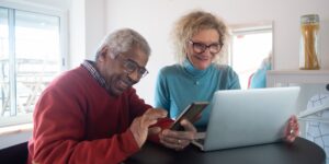 A senior couple using digital travel technology at an airport kiosk.