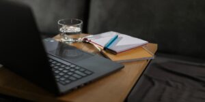 A glass of water and a notebook on a kitchen table, representing healthy daily habits for seniors.