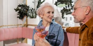A senior person enjoying a glass of water in a sunlit room.