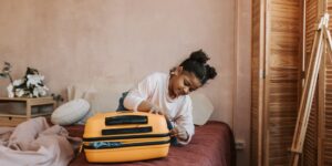 An organized, lightweight suitcase packed for travel on a bed.