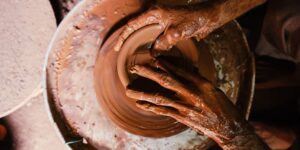 A close-up view of hands working with clay in a peaceful pottery studio.