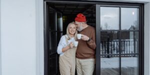 A senior couple enjoying a scenic winter train ride through snowy mountains.