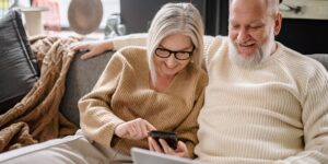 An elderly couple using a smartphone to find a restaurant in a bright, modern, accessible dining space.