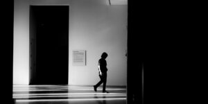 A quiet, modern art gallery hallway with natural light and a bench.
