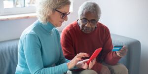 A senior couple using a smartphone at a modern, accessible bus stop.