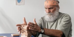 An elderly person carving a linoleum block in a well-lit studio.