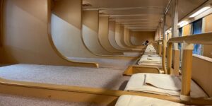 A modern, comfortable overnight train cabin at sunset.