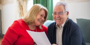 A senior couple checking their travel documents at a train station.
