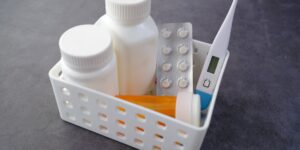 A travel medicine kit organized on a table with a tropical view in the background.