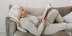 An active senior practicing correct seated posture in a comfortable home setting.