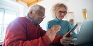 An older couple using a smartphone to navigate a historical site.