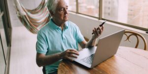 A senior person using a secure digital device to access services.
