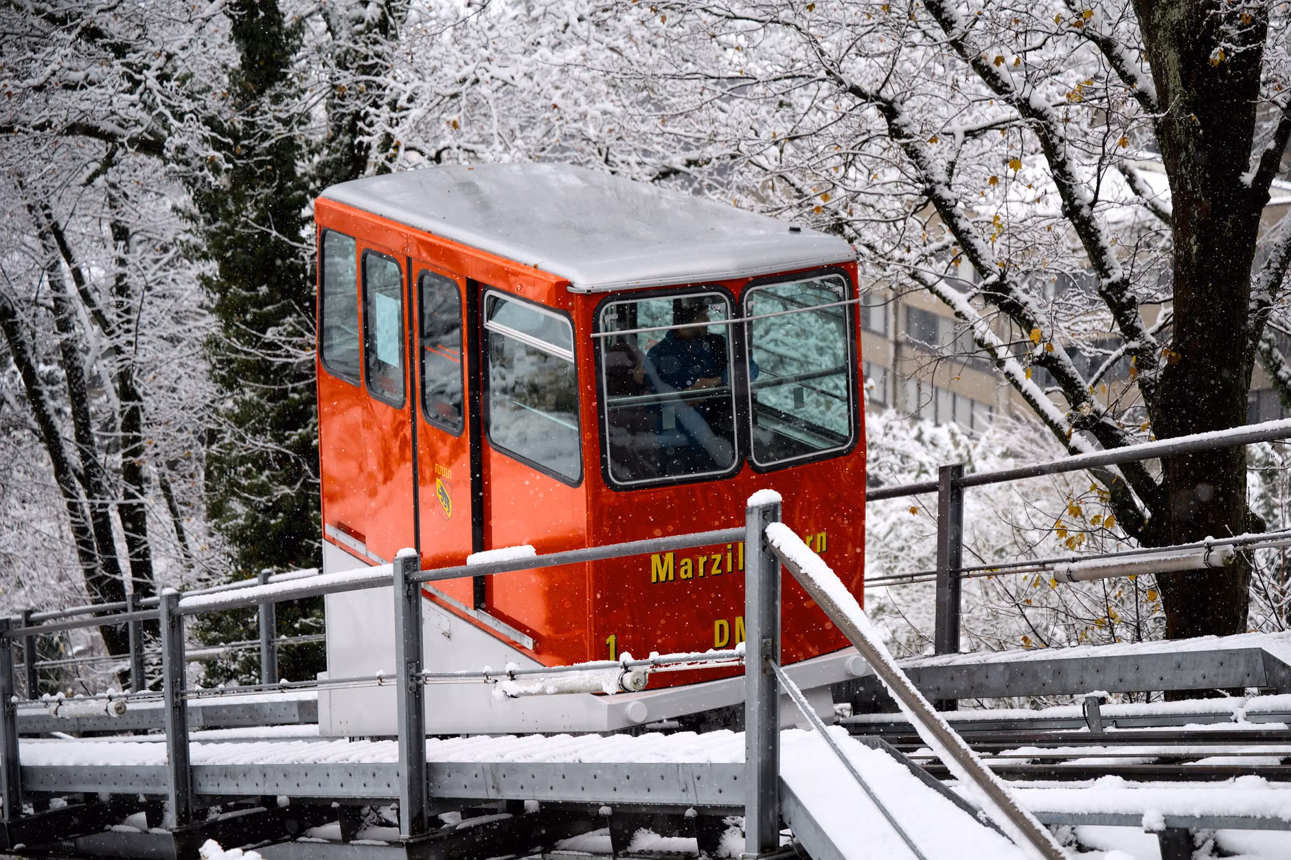 Senior traveler enjoying the view from inside a funicular carriage.