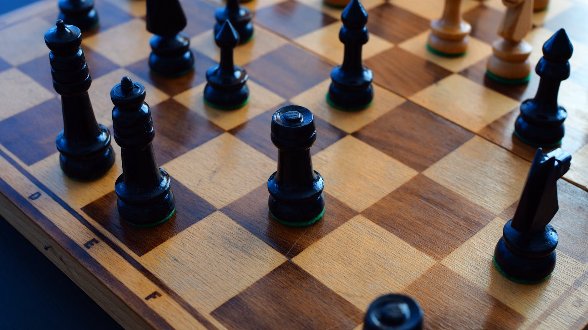 Sharpening the Mind: The Cognitive Utility of Strategic Chess for Adults 1 A close-up of a wooden chessboard mid-game.