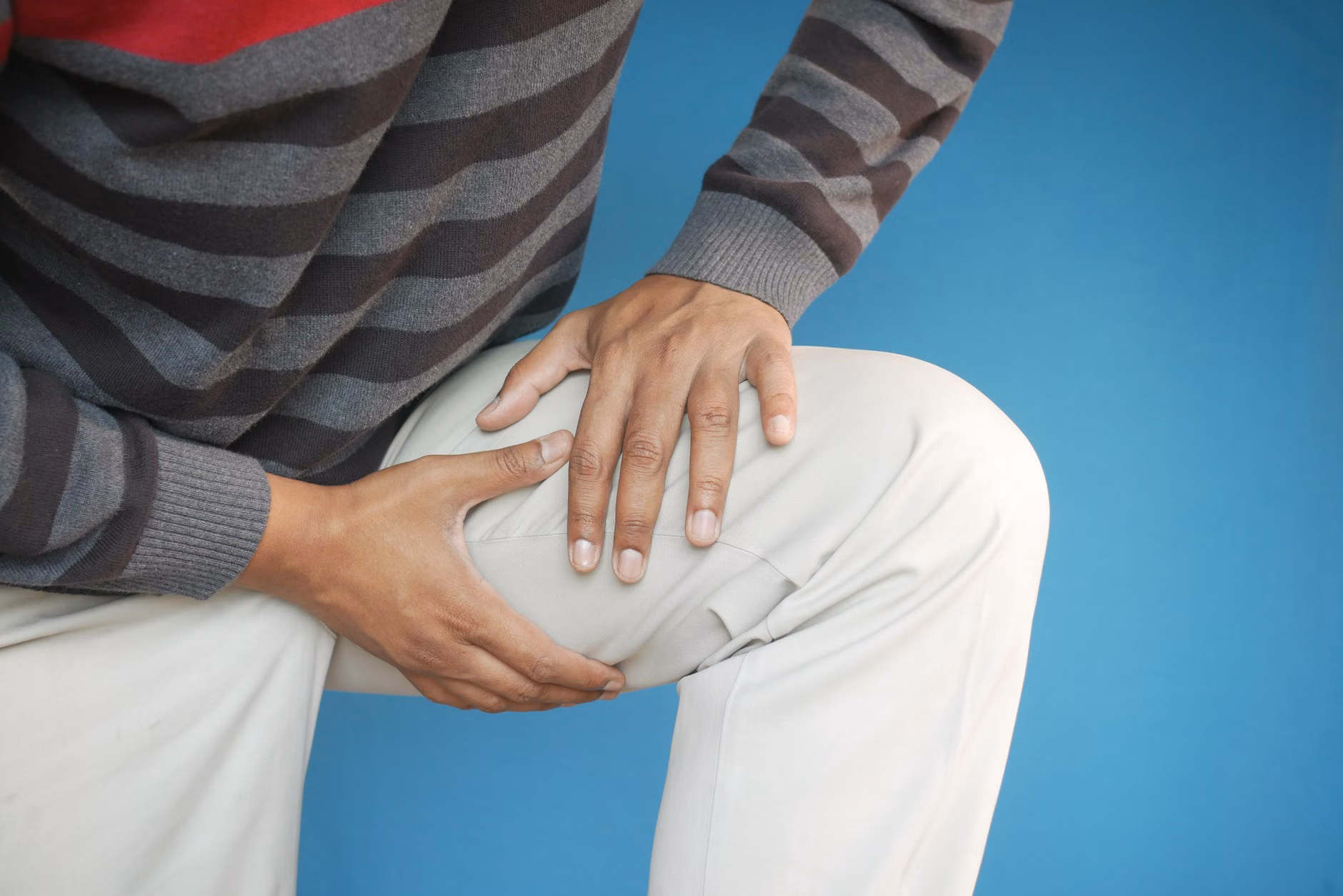 Close-up of hands supporting the knee during circular mobility exercises.