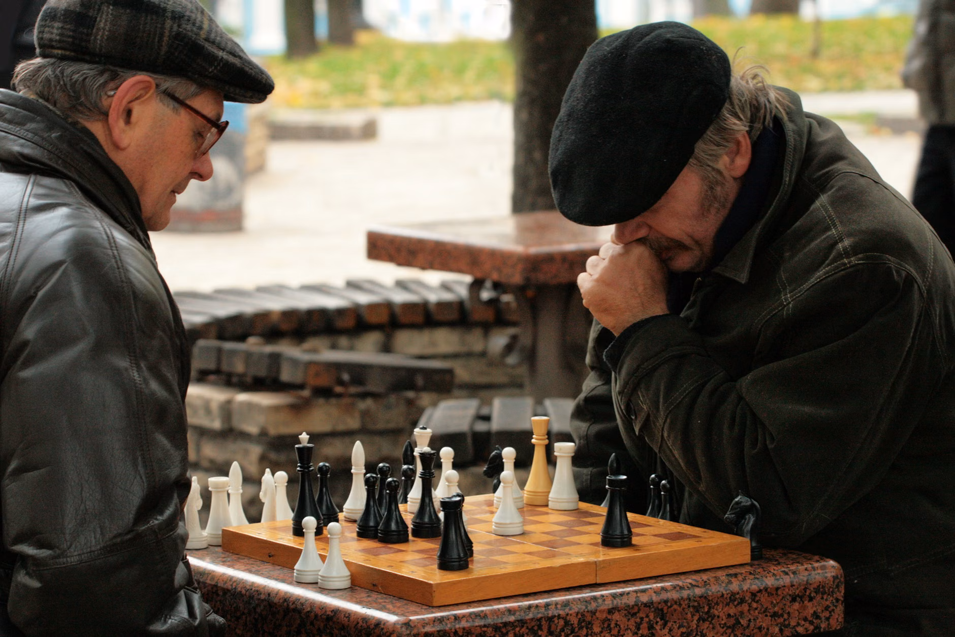 An older adult concentrating on a chess game.